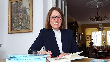 Annette Kliebenstein signiert ein Buch bei sich zu Hause. Annette Kliebenstein signiert ein Buch bei sich zu Hause.