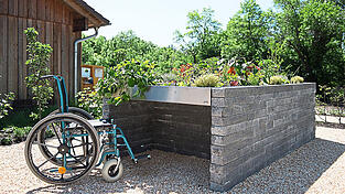 Hochbeete ermöglichen rückenschonendes Arbeiten und sind so bis ins hohe Alter eine Option für den Obst- und Gemüseanbau im heimischen Garten. Es gibt auch Hochbeete - wie auf diesem Bild - eigens für Menschen im Rollstuhl, ähnlich die sogenannten Tischbeete.