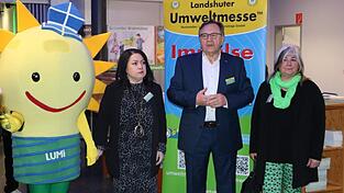 Das Maskottchen der Umweltmesse &bdquo;Lumi&ldquo; (von links), die gesch&auml;ftsf&uuml;hrende Gesellschafterin Stefanie M&ouml;ller, der Urheber und gesch&auml;ftsf&uuml;hrende Gesellschafter Rudolf Schnur und die Gesellschafterin Andrea Lapper hie&szlig;en den bayerischen Wirtschaftsminister und die Ehreng&auml;ste auf der Messe willkommen.