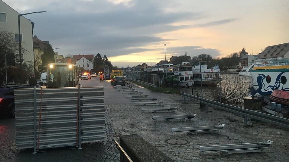 Bei Sonnenaufgang errichten st&auml;dtische Mitarbeiter in der Werftstra&szlig;e den Hochwasserschutz.