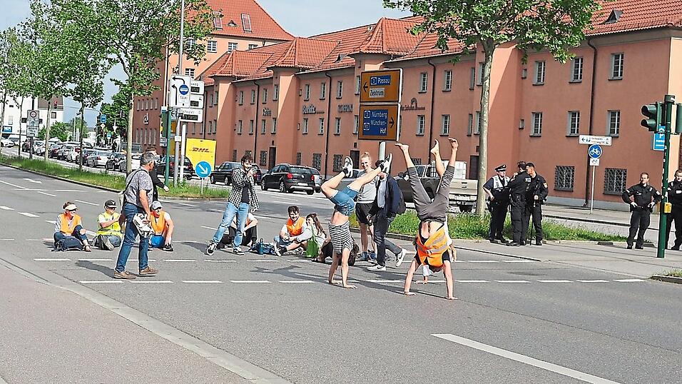 Die Aktivisten der Letzten Generation Regensburg vertrieben sich die Zeit auf der Straße vor den Arcaden am Mittwochabend unter anderem mit Handständen. Die Aktivisten der Letzten Generation Regensburg vertrieben sich die Zeit auf der Straße vor den Arcaden am Mittwochabend unter anderem mit Handständen.