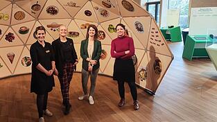 Claudia Halbritter (Nawareum), Marion Grether, Jana Grasser (beide Deutsches Museum N&uuml;rnberg) und Dr. Vanessa Roden (Direktorin Nawareum) am Eingang der Ausstellung - im Hintergrund ein Teil davon.