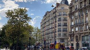 Einsatzkr&auml;fte stehen in einer abgesperrten Stra&szlig;e in Paris.