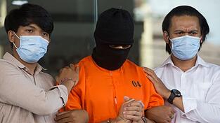 Der Verdächtige wurde nach seiner Festnahme im Mai in einem orangen Sträflingsanzug der Presse vorgeführt.