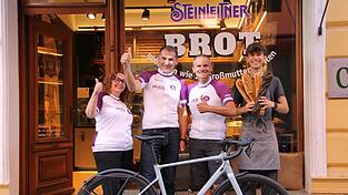 Vor der Bäckerei stehen (v.l.) Doris Weilert, die Fahrerin des Verpflegungswagens, die Radler Anton Huber und Raffaele Antonucci und der Bäckereiverkäufer Felix Pöllmann.