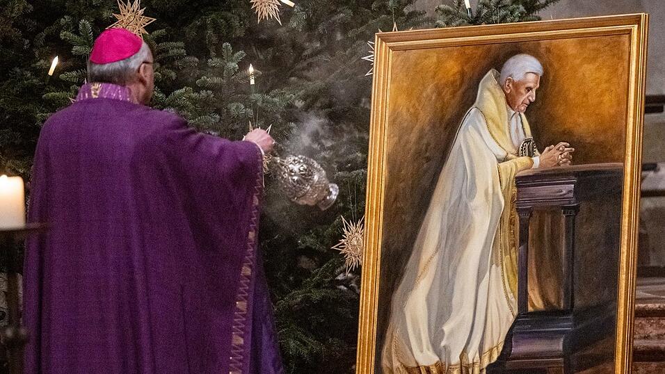 Rudolf Voderholzer, Bischof von Regensburg, vor einem Gem&auml;lde mit dem emeritierten Papst Benedikt XVI. von dem K&uuml;nstler Hermann J. Heiss im Dom St. Peter.
