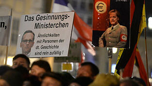 Anhänger des Bündnisses Pegida (Patriotische Europäer die Islamisierung des Abendlandes) zeigen ein Schild mit der Aufschrift 'das Gesinnungs-Ministerchen Ähnlichkeiten mit PErsonen der dt. Geschichte sind rein zufällig' und einem Bild des Bundesjustizminister Heiko Maas am Abend am 02.11.2015 auf dem Neumarkt in Dresden während einer Kundgebung.