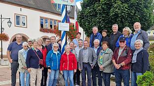 Der Maibaum vor dem Rathaus in Rittershoffen mit den Vertretern der Gemeinde Rittershoffen, den Gästen aus Aigrefeuille, Schönberg und Velden.