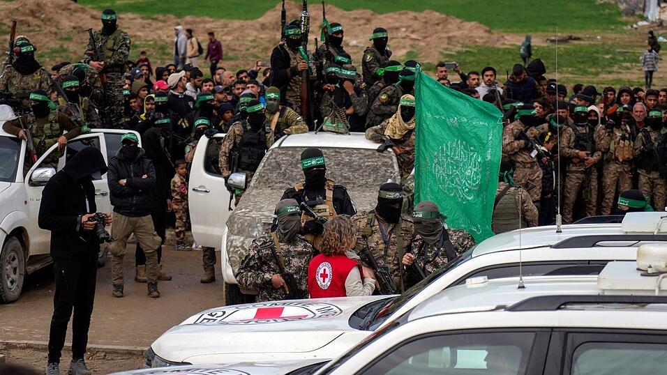 Eine Vertreterin des Roten Kreuzes spricht mit Hamas-Mitgliedern. Eine Vertreterin des Roten Kreuzes spricht mit Hamas-Mitgliedern.