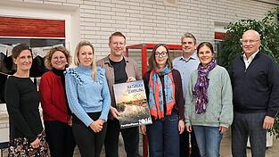 Jürgen Eifler (4.v.l.), Vorsitzender des Schulfördervereins, mit dem Vorstandsteam, den Beisitzern und stellvertretender Schulleiterin Stephanie Weiß (2.v.l.). Im Rahmen der Jahreshauptversammlung wurde auch der neue Kalender und Familienplaner vorgestellt, deren Verkaufserlös an den Förderverein fließt.