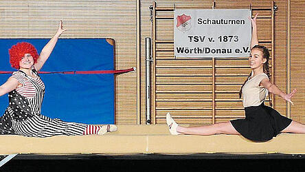 Spagat auf dem Balken.