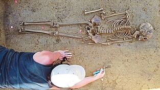 Eine Mitarbeiterin von Richter legt ein Grab aus dem Fr&uuml;hmittelalter frei.