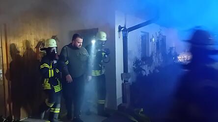 Die Atemschutzträger aus Forsthart bringen eine 'gerettete Person' aus der verrauchten Garage.