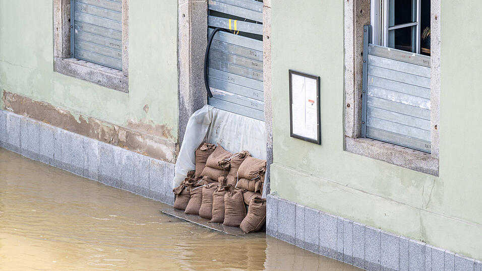 Sandsäcke liegen vor einem Hauseingang in der Altstadt Passau. Die Hochwasserlage bleibt angespannt, weil neuer Regen erwartet wird. 