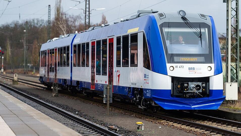 Ein Nahverkehrszug der Bayerischen Regiobahn steht in einem Bahnhof.