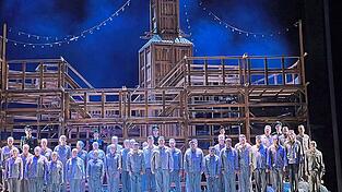 Das hölzerne Bühnenbild von „Die Passagierin“ symbolisiert zugleich ein Luxuskreuzfahrtschiff und die Baracken eines Kriegsgefangenenlagers. Das hölzerne Bühnenbild von „Die Passagierin“ symbolisiert zugleich ein Luxuskreuzfahrtschiff und die Baracken eines Kriegsgefangenenlagers.