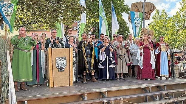 Auf der B&uuml;hne haben sich alle R&auml;te von Pledelingen versammelt. B&uuml;rgermeister Hans Schmalhofer hie&szlig; das Volk willkommen.
