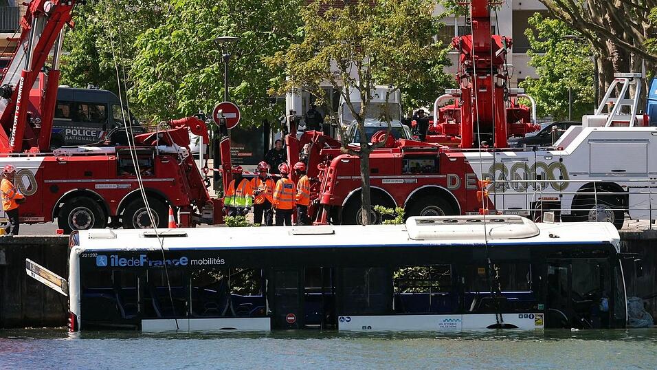Der Linienbus wird von Kr&auml;nen aus dem Fluss geborgen.