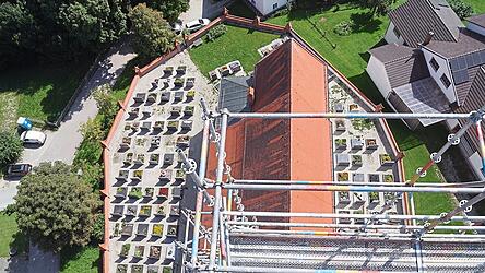 Blick vom eingerüsteten Turm der Seyboldsdorfer Pfarrkirche St. Johannes in die Tiefe: Aus dieser Perspektive betrachtet wirken Kirche, Friedhof und Einfriedungsmauer wie der Bug eines Schiffes.