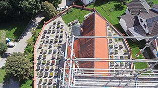 Blick vom eingerüsteten Turm der Seyboldsdorfer Pfarrkirche St. Johannes in die Tiefe: Aus dieser Perspektive betrachtet wirken Kirche, Friedhof und Einfriedungsmauer wie der Bug eines Schiffes.