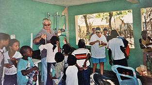 Marjorie (3. v.r.) und Jim Hughes (Mitte) brachten bei ihren jährlichen Reisen in die Dominikanische Republik Geschenke wie Bleistifte, Kugelschreiber und Lineale für Schulkinder mit. Nach ihrer Auswanderung in die Karibik unterstützten sie die Buben und Mädchen weiterhin. Diese Aufnahme entstand kurz nach ihrem Umzug.