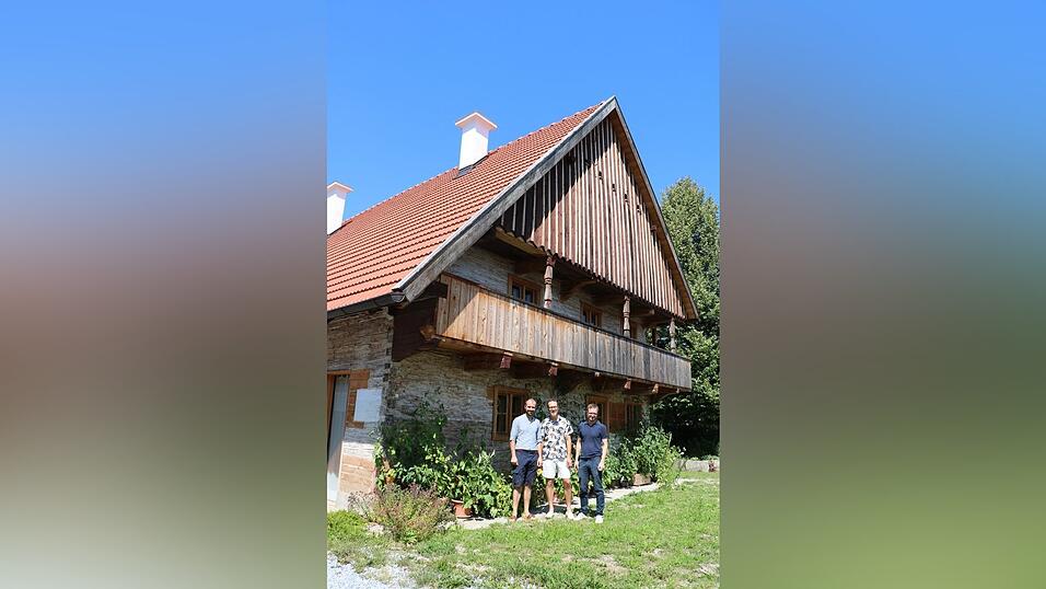 Die Bauherren Sebastian Stanglmaier (v.l.) und Max Graf mit dem Architekten Michael Feil vor der Klingls&ouml;lde mit dem markanten 'Frackdach'.