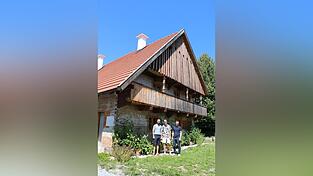 Die Bauherren Sebastian Stanglmaier (v.l.) und Max Graf mit dem Architekten Michael Feil vor der Klingls&ouml;lde mit dem markanten 'Frackdach'.