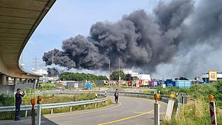 Eine dunkle Rauchwolke steigt über dem Chempark auf. Einsatzkräfte der Werkfeuerwehr sind im Einsatz.