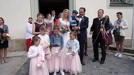 Das Brautpaar mit den Trauzeugen und Verwandten beim Durchschreiten des Spaliers der Vereine beim Verlassen der Pfarrkirche