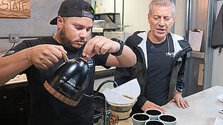 Eine Kostprobe des schwarzen Heißgetränks mit Wilford Lamastus und seinem Sohn, die eine Kaffeeplantage führen. Eine Kostprobe des schwarzen Heißgetränks mit Wilford Lamastus und seinem Sohn, die eine Kaffeeplantage führen.