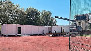 Der Aufbau der Containerschule auf dem Sportplatz des Gymnasiums hat begonnen. Der Aufbau der Containerschule auf dem Sportplatz des Gymnasiums hat begonnen.