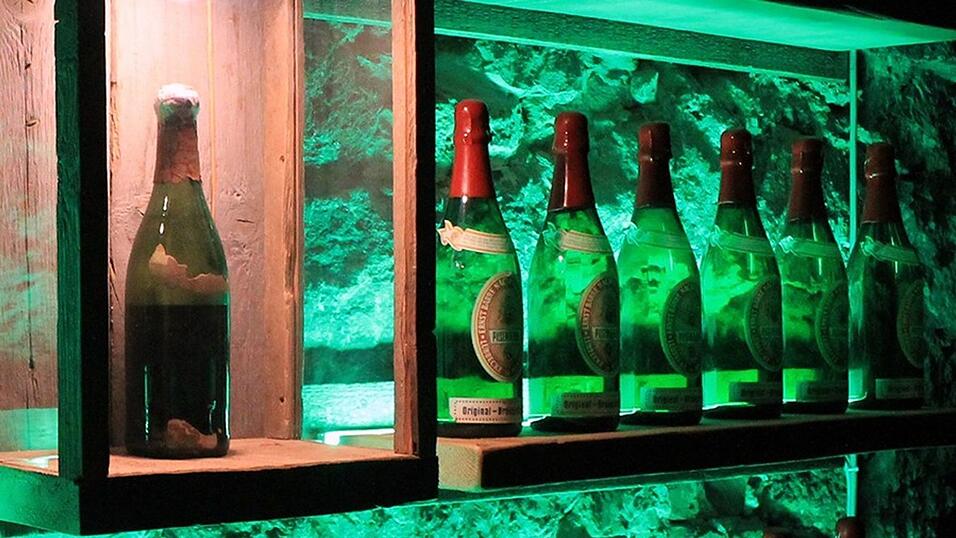 Eine fast 140 Jahre alte Flasche Bier steht in einem Regal.