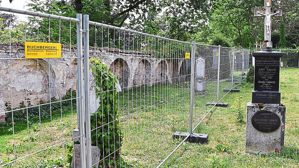 Ein Bauzaun steht vor der maroden Friedhofsmauer. Ein Bauzaun steht vor der maroden Friedhofsmauer.