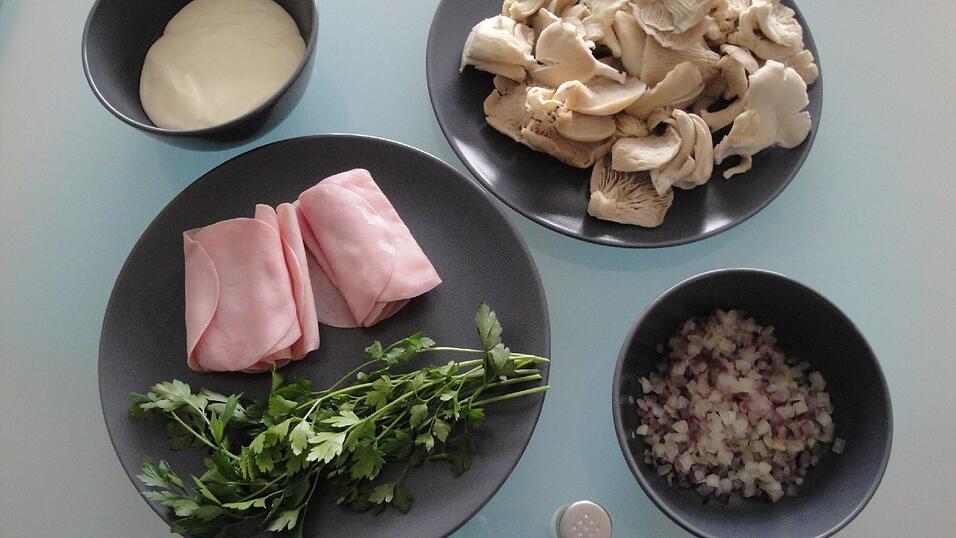 Die Zutaten für die Austernpilz-Schinken-Pfanne: frische Austernpilze, Kochschinken, Schmelzkäse, Petersilie und eine Zwiebel.