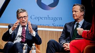 Der fr&uuml;here Nato-Generalsekret&auml;r Anders Fogh Rasmussen (l) wirbt f&uuml;r einen Zusammenschluss der demokratischen Mittelm&auml;chte. Hier redet er mit dem  ehemaligen britischen Premierminister James Cameron auf einem Demokratie-Gipfel in Kopenhagen. (Archivbild)