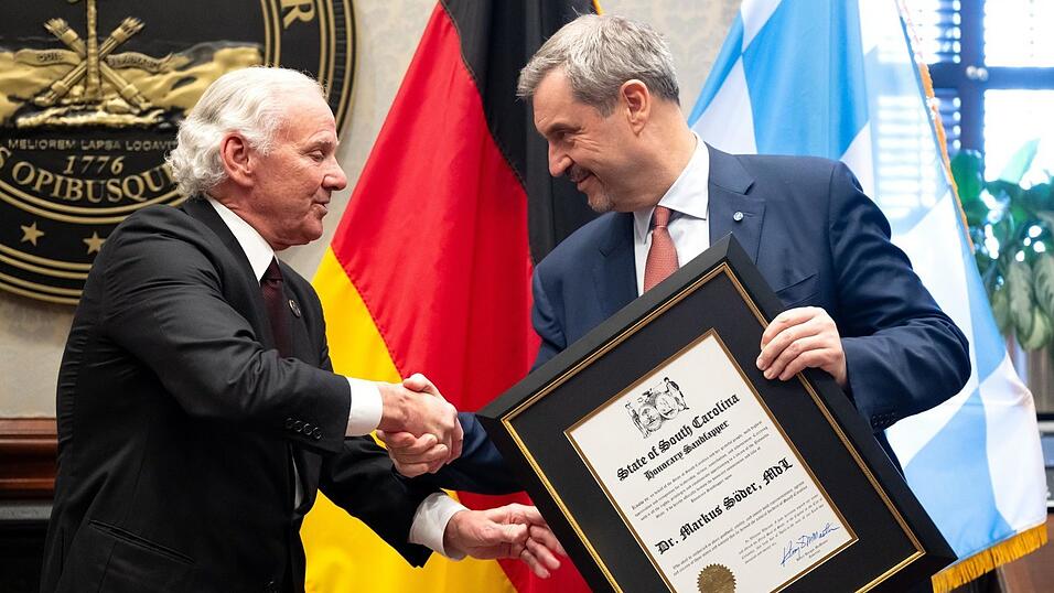 Gouverneur Henry McMaster (l.) macht Ministerpr&auml;sident Markus S&ouml;der zum &bdquo;Honorary Sandlapper&ldquo;. Die Auszeichnung des Gouverneurs von South Carolina gibt es seit 2022 und wird an Nicht-Einwohner verliehen, die sich um den US-Bundesstaat verdient gemacht haben.