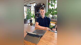 Benedict Jacob sitzt zu Hause in Haselbach am Esstisch. Er freut sich über sein erstes Buch „Verlassene Pfade“. Er hat es komplett selbst geschrieben und auch das Layout dazu erstellt.