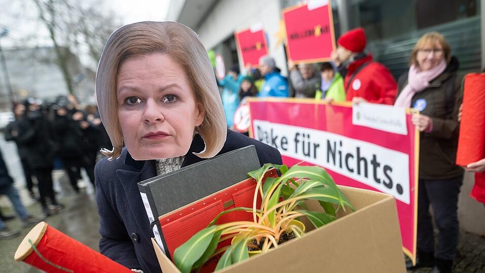 Eine Aktivistin demonstriert mit einer Maske von Bundesinnenministerin Nancy Faeser. Eine Aktivistin demonstriert mit einer Maske von Bundesinnenministerin Nancy Faeser.