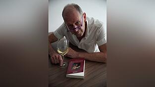 Andreas Ehl mit seinem neuen Werk und einem trockenen Weißwein. Den trinkt er am liebsten.