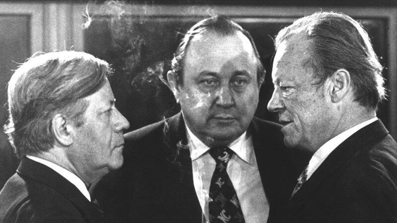 Vor Beginn der Sitzung im Bonner Bundeskanzleramt unterhalten sich am 13.12.1976 (l-r): Bundeskanzler Helmut Schmidt (SPD), Bundesau&szlig;enminister Hans-Dietrich Genscher (FDP) und der SPD-Vorsitzende Willy Brandt.