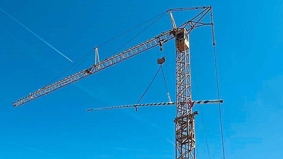 An einem Kran gesichert baumelt der Maibaum bis zur Ausl&ouml;se.