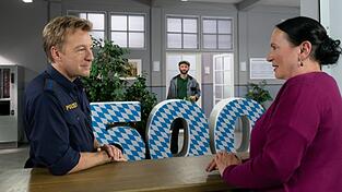 Polizeihauptmeister Mohr (Max Müller, l.) und Marianne Grasegger (Ursula Maria Burkhart, r.) wundern sich über die '500', die Hausmeister Hannes Winkler (Steffen Wolf, M.) aufgestellt hat, undatierte Szene aus der ZDF-Serie 'Rosenheim-Cops'. Vom ZDF-Dauerbrenner gibt es jetzt genau 500 Folgen.