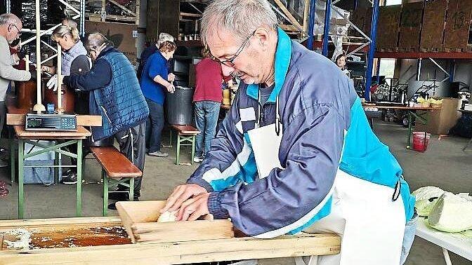 Der Vorsitzende Ludwig Kleeberger zeigt, dass Krauthobeln einiges an Muskelkraft erfordert. Der Vorsitzende Ludwig Kleeberger zeigt, dass Krauthobeln einiges an Muskelkraft erfordert.