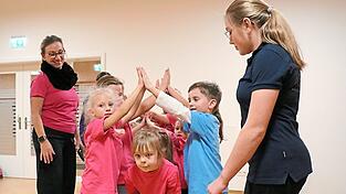 Mit Musik macht Bewegung noch mehr Spaß - durch den Tunnel und hinten wieder aufstellen, mit Trainerin Trixi Berg (links) und Co-Trainerin Johanna. Mit Musik macht Bewegung noch mehr Spaß - durch den Tunnel und hinten wieder aufstellen, mit Trainerin Trixi Berg (links) und Co-Trainerin Johanna.