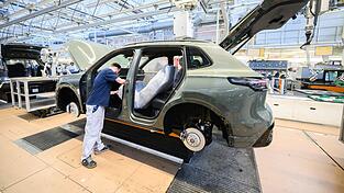 Mitarbeiter montieren in Wolfsburg den VW Tayron. (Archivbild)