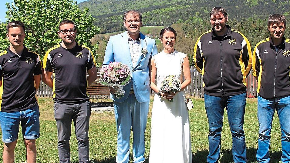 Das strahlende Brautpaar Kerstin und Wolfgang Schmid mit den Fu&szlig;ballern des SC Arrach.