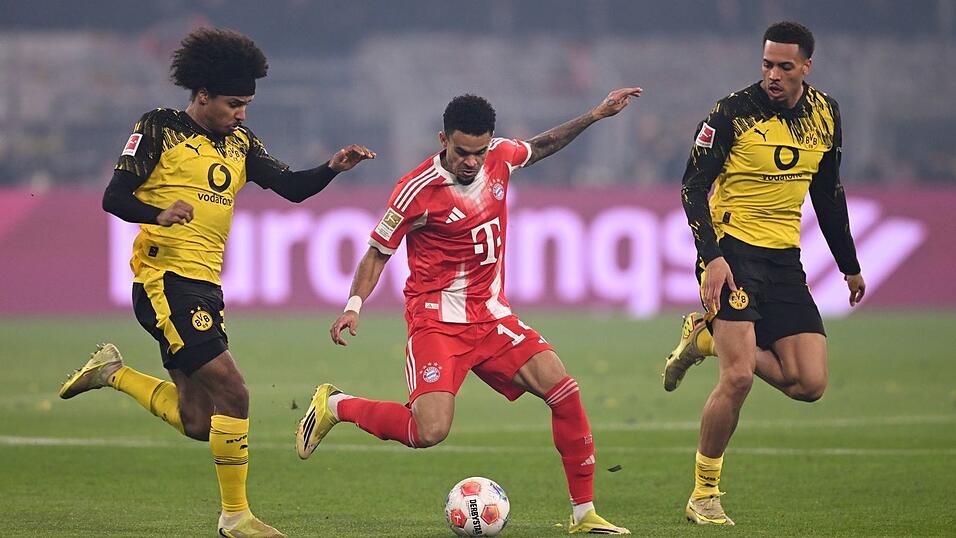 Luis Díaz umzingelt von zwei Dortmundern. Luis Díaz umzingelt von zwei Dortmundern.