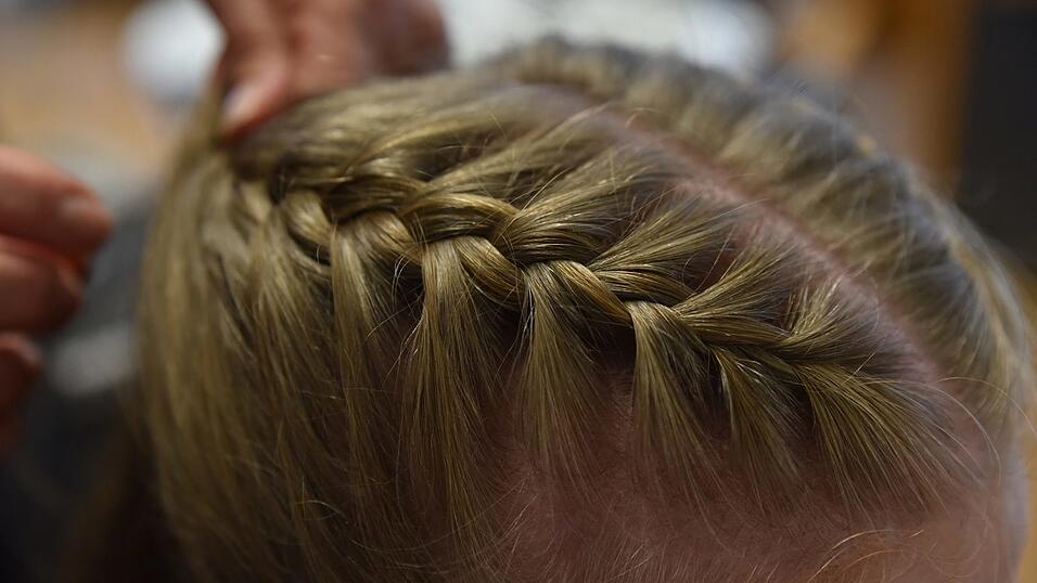 Parallel dazu einen weiteren Zopf auf der anderen Seite flechten. Parallel dazu einen weiteren Zopf auf der anderen Seite flechten.