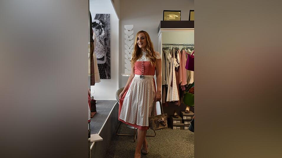 Auch dieses Dirndl trägt man am besten mit einer hochgeschlossenen Bluse. Die passenden Schuhe und eine Tasche runden den Look ab.