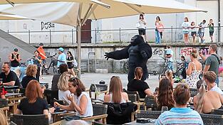 Plötzlich genießen die Cafégäste eine Show aus erster Reihe: Ein Gorilla tollt über den Platz.
